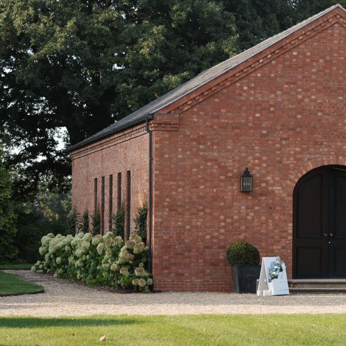 The Grange Leverton ceremony hall exterior with brick architecture and hydrangeas